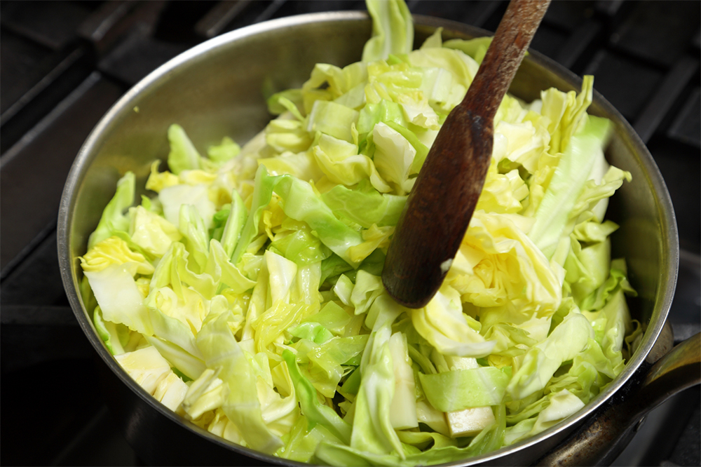 キャベツがしんなりするまでは、側面からヘラを入れて返し、熱がまんべんなく行き渡るようにする。 POINT：絶対に焦がさない。香りだけでなく、色も茶色っぽくなるので、焦げが見えたらすぐに除去。鍋底が常にピカピカな状態を維持する。 ［４］細火で蒸し煮状態に