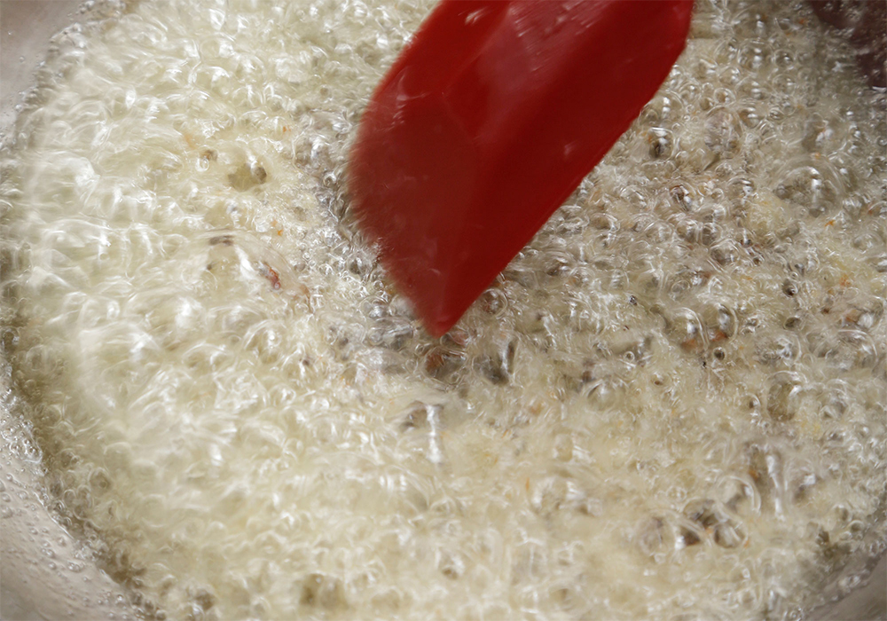 [３]ペーストを加える スパイスから立つ泡が大きくなったら、ニンニクショウガペーストを加える。