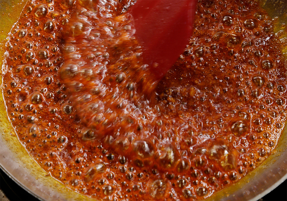 [４]仕上げ用スパイスを加える 全体にジュワーッと泡立ち、キツネ色に色付いたら仕上げ用スパイスを入れる。中火をキープしながらしばらくかき混ぜ、香りを立たせる。