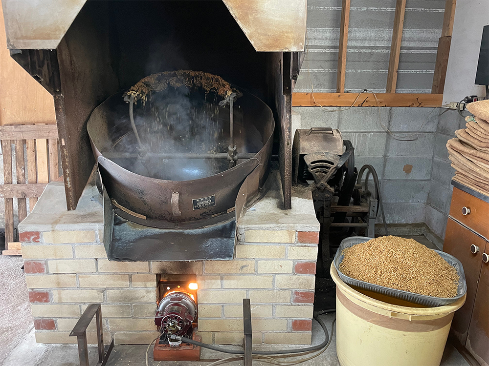 ２．一番炒り 釜（家庭だと中華鍋がおすすめ）に入れ、少しずつ炒る。パチパチと籾の弾ける音がし始めたら、手でもんでみて、籾殻がむけるようになったらOK。これを熱いうちに臼に入れて杵でついた行程が室町時代から戦時中まで伝わる製法。