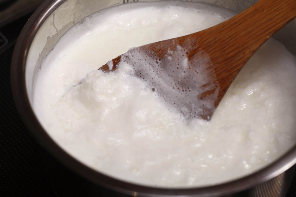 かき混ぜながら、加熱を続ける。表面に白い塊が浮かび始める。 [６] 表面を大きな塊が覆う