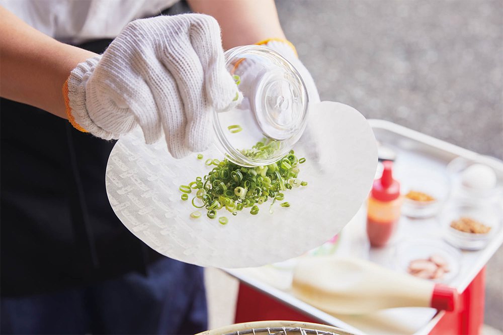 ライスペーパーに青ネギをのせる（炭火はあっという間に火が入るので、先にネギをのせてから網へ）。