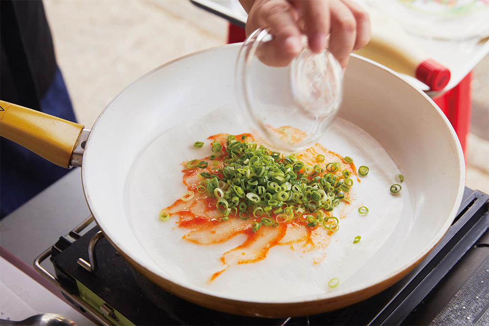 スプーンの背でチリソースを全体に伸ばして平らに戻し、後は炭火の手順２と同様に、残りの材料をのせる。