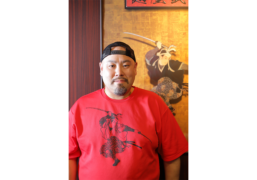 杉山浩二さん。様々なラーメン店の調理を経て、８年前から麺屋武蔵のレシピ開発を担当する。ラーメン作り18 年。日本薬科大学と共同で開発した薬膳ラーメンや、宮城県復興支援のために同県産のほやを活用をした調味料「ほや醤」を開発するなど、コラボレーションで斬新なメニュー開発を続ける。『抽象と捨象のラーメン調理法』（麺屋武蔵著／旭屋出版）。