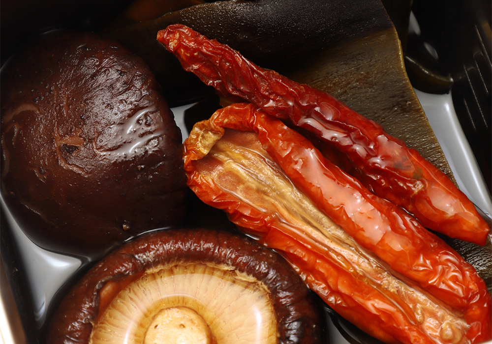 【下準備】 干しシイタケと昆布、ドライトマトを一晩水出しする。トマトはグアニル酸とグルタミン酸の両方を多く含み、醤油とも相性がよい。 ［１］酒類を煮切る