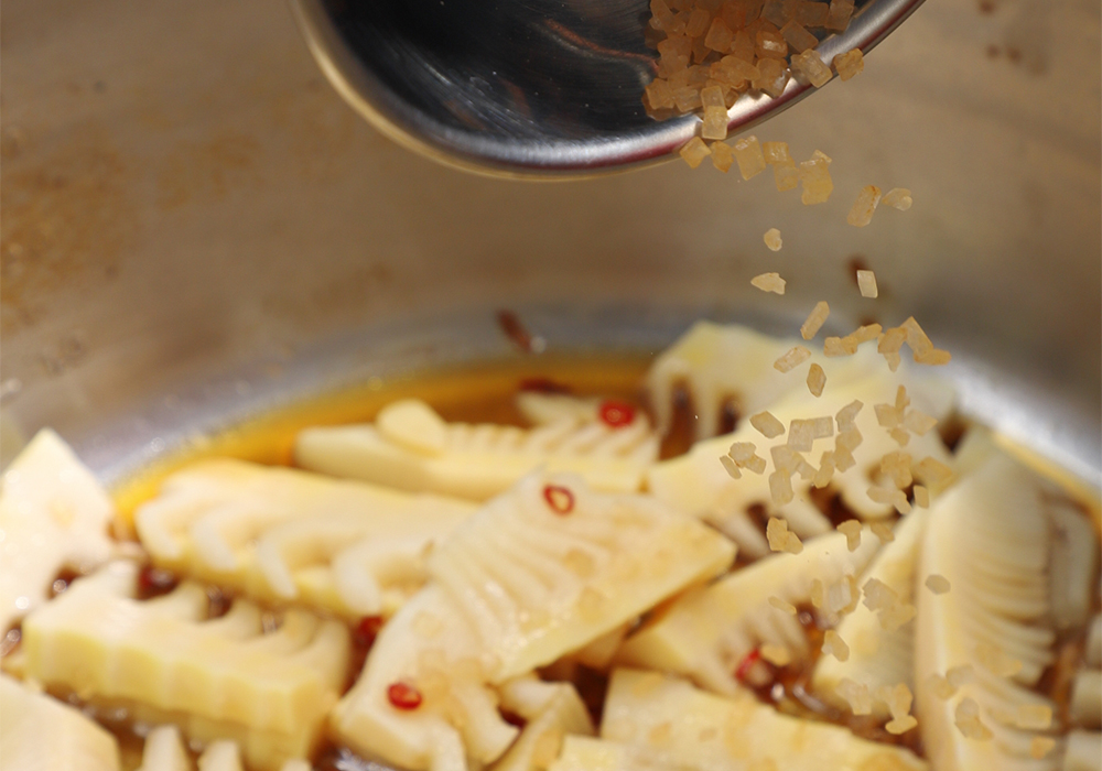 中華鍋に油を引き、筍と赤唐辛子を中火で炒める。 ［２］たれを煮絡める