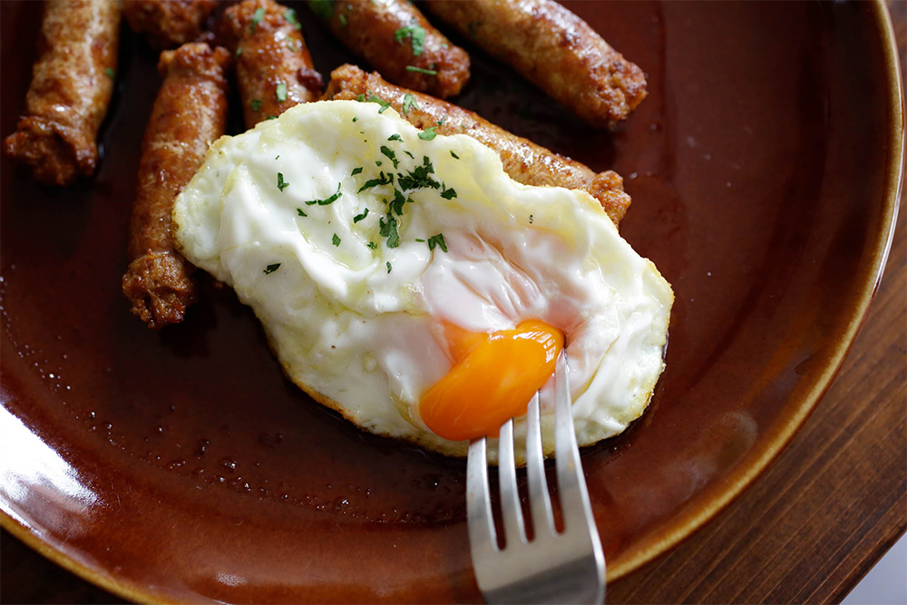 チストラの目玉焼きのせ 羊の腸に詰めた細長いソーセージ「チストラ」は途中でねじらず、使う時にハサミで必要な長さにカットする。表面をパリッと焼いたチストラに、黄身がまだトロトロの目玉焼きをのせれば、絶好のソースに。