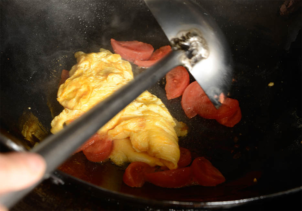 [７]固まる寸前に火を止める 再び、外から内側に向かって卵をやさしく返す。卵が固まる寸前に火を止め、器にとる。