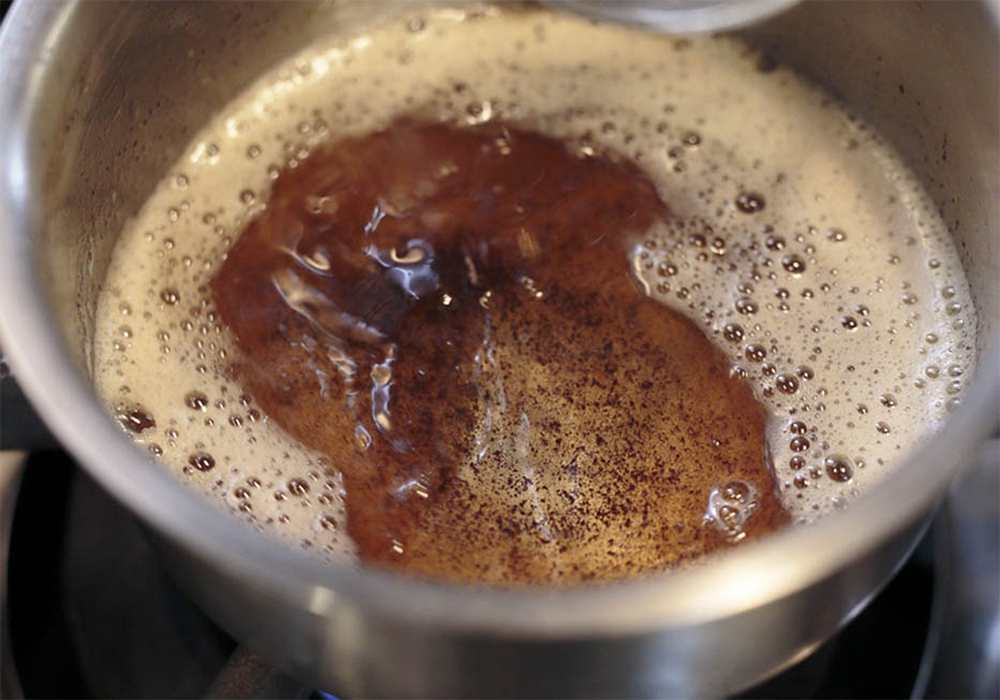 [２]焦がしバターを作る 小鍋にバターを入れ、中強火で熱する。ホイッパーでかき混ぜながら、溶けて、泡が立ち、茶色く色付くまで熱したら容器に移し、氷水をあてて粗熱を取る。