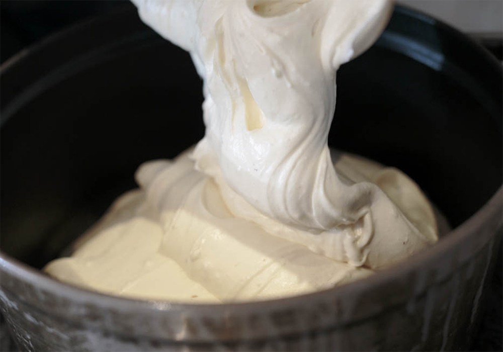 [５]ヘラで均一に混ぜる ４に薄力粉をふるい入れ、泡を潰さないよう、生地を切るようにヘラで混ぜる。均一に混ざったら、鋳鉄鍋に生地を流す。