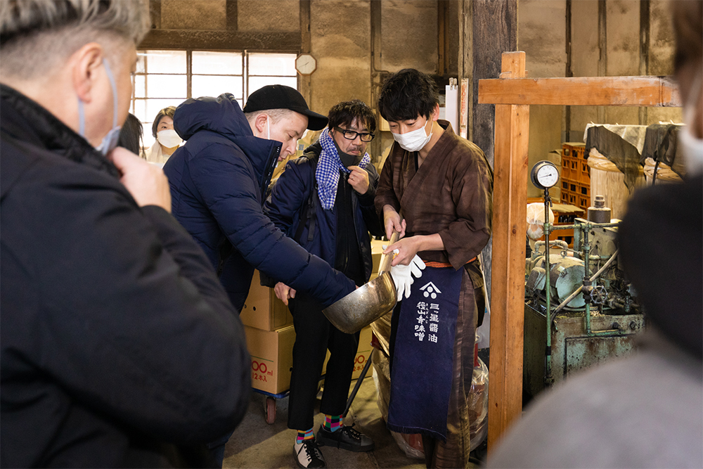 搾りたての醤油の味を見るシェフたち。「火入れをすることで、さらに味が深まる」と野村さん。