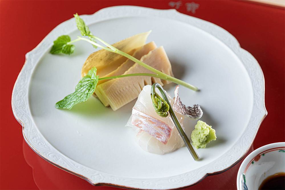 田辺市・龍神村から届いた朝掘りの筍がテーブルに。鮮度を保つために土の中にいる状態で布袋に入れ、届けてもらう。刺身でいただける新鮮さ、みずみずしさ。焼けば、トウモロコシのように、ほっくりと香ばしい。