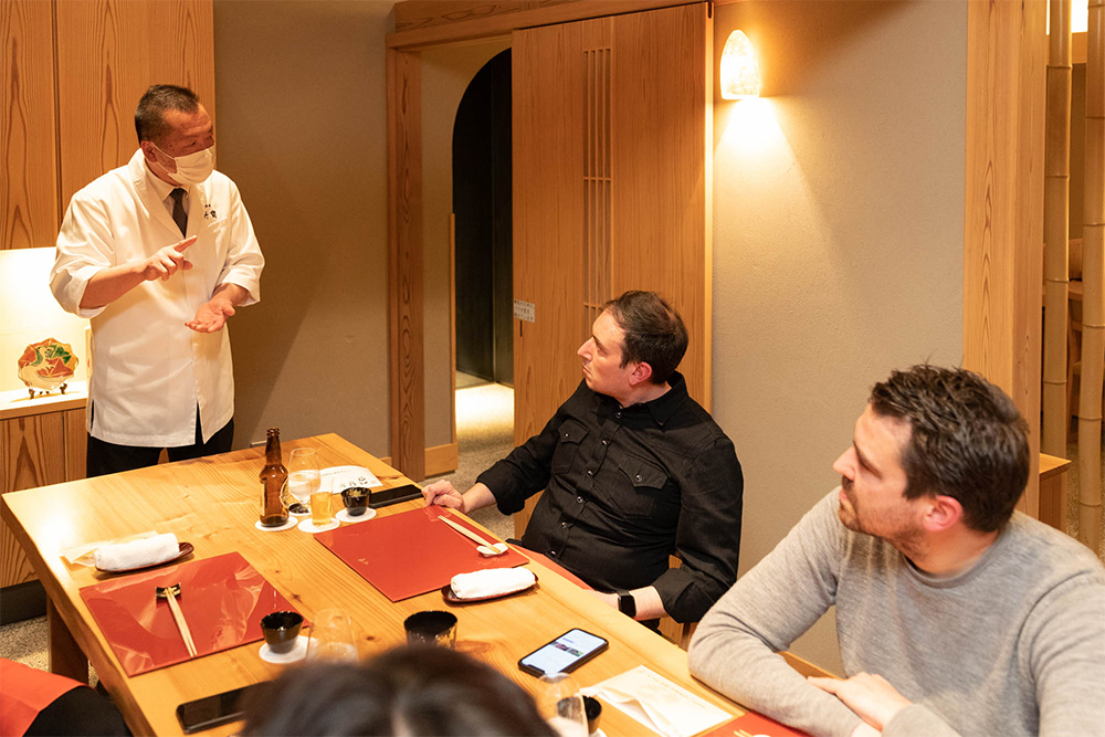 だしをひき分ける手法について、竹中料理長がレクチャー。真剣な表情で説明に聞き入るシェフ２人。