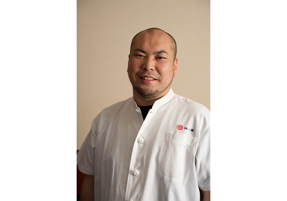 四川料理「中国料理仙ノ孫」オーナーシェフ。1979年生まれ、大分県出身。中村調理製菓専門学校を卒業後、「龍の子」、「ホテル雅叙園東京」の「旬遊記」、上海のホテルなどで研鑽を積み、2009年現店開業。医食同源をモットーに、漢方薬や豆板醤、山椒油などの自家製調味料、大分の実家から届く旬の野菜を取り入れて自然な味わいを出す。「ミシュラン東京2022」でビブグルマン獲得。