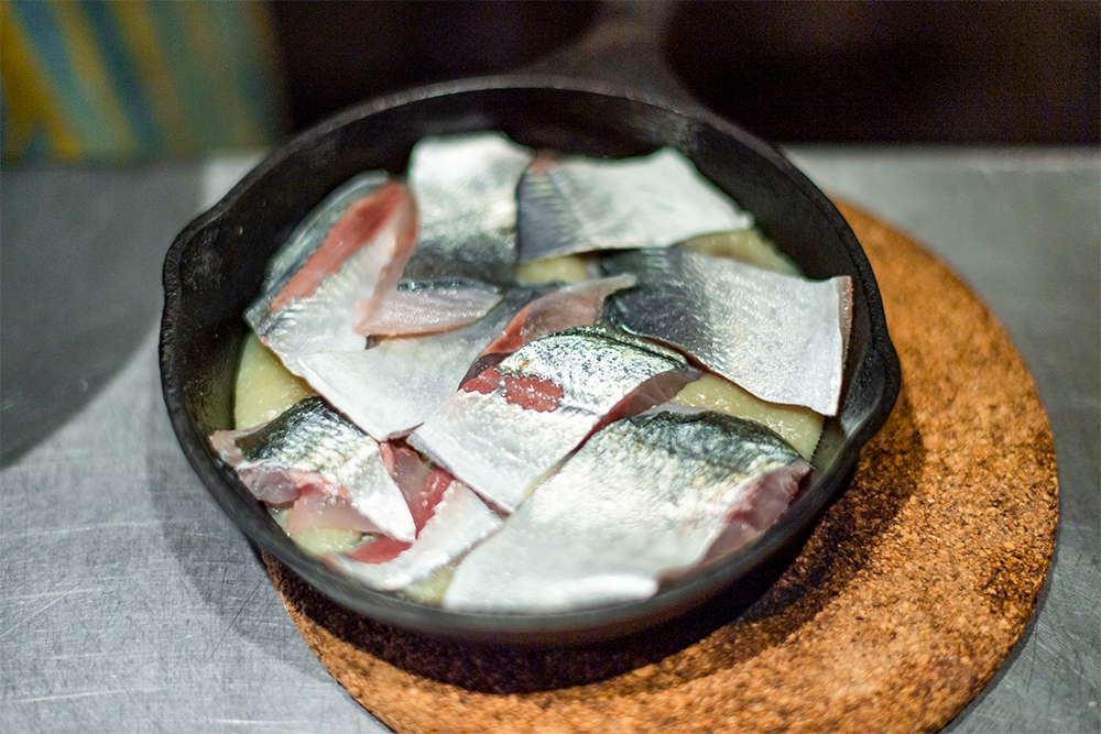 [３] スキレットにE.V.オリーブ油を多めに敷き、ジャガイモのピュレを流し込む。上に２を並べる。