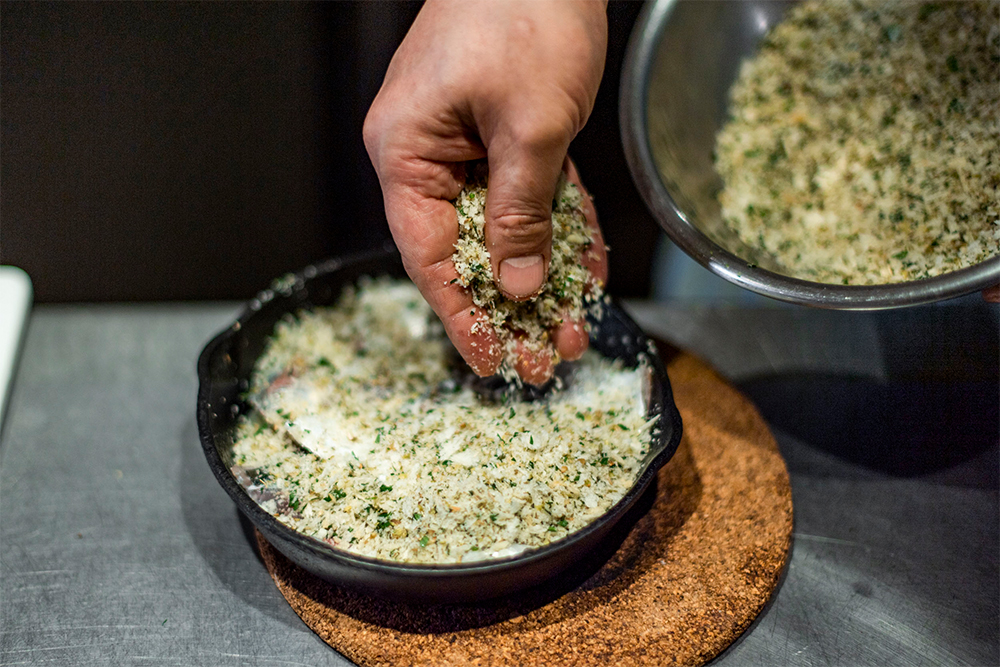 [４] 香草パン粉をたっぷりのせる。 POINT：隙間なく蓋をするイメージで。