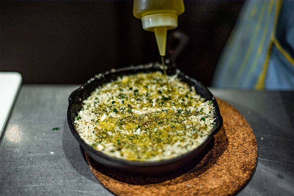 [５] E.V.オリーブ油を回しかける。スキレットを火にかけ、スキレットが熱くなったら火を止める