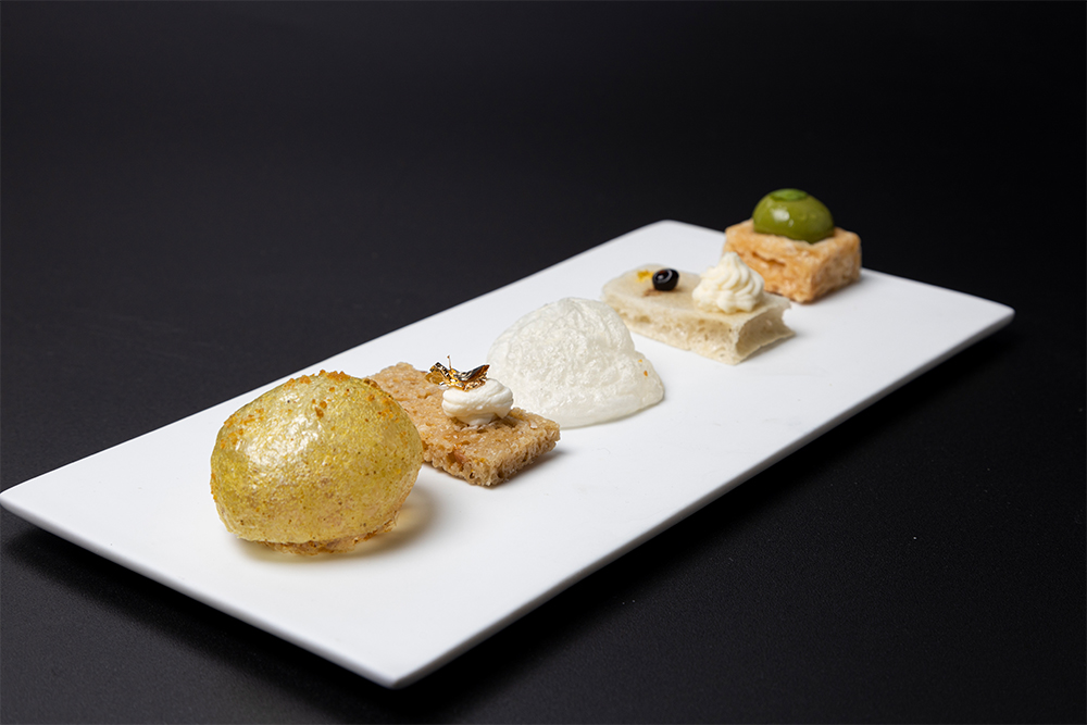 左から。葛粉、タピオカ粉、カレー粉、砂糖を水で練ってレンジ調理したスナック／ゴルゴンゾーラチーズのスナック／イディアサバルチーズのエスプーマ／パルミジャーノチーズのスナックにモデナ酢とパルミジャーノクリーム／箱型にレンジ調理したパルミジャーノスナックにジェノベーゼソース。葛粉やタピオカ粉を使った生地はレンジにかけると空洞状に膨らむ。