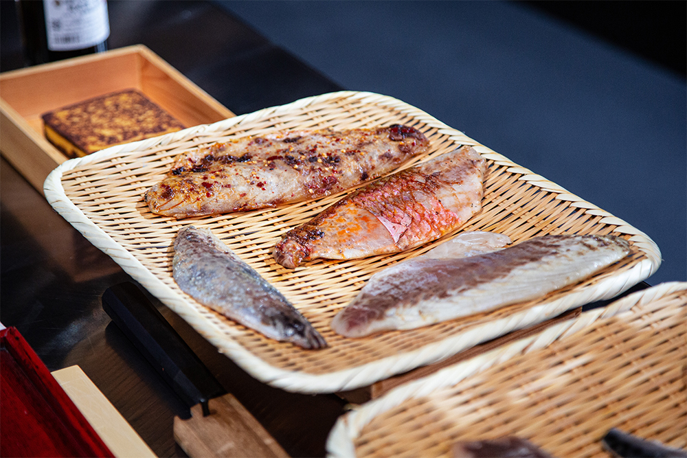 握りにはマグロ、カツオ、サバ、ボラ、ヨーロッパヘダイ、スズキ、ヒメジなどを使う。ヘダイにはE.V.オリーブ油、スズキには醤油と唐辛子のオイル、アジにはリオハ特産の唐辛子オイルを、それぞれ炙った後に塗る。