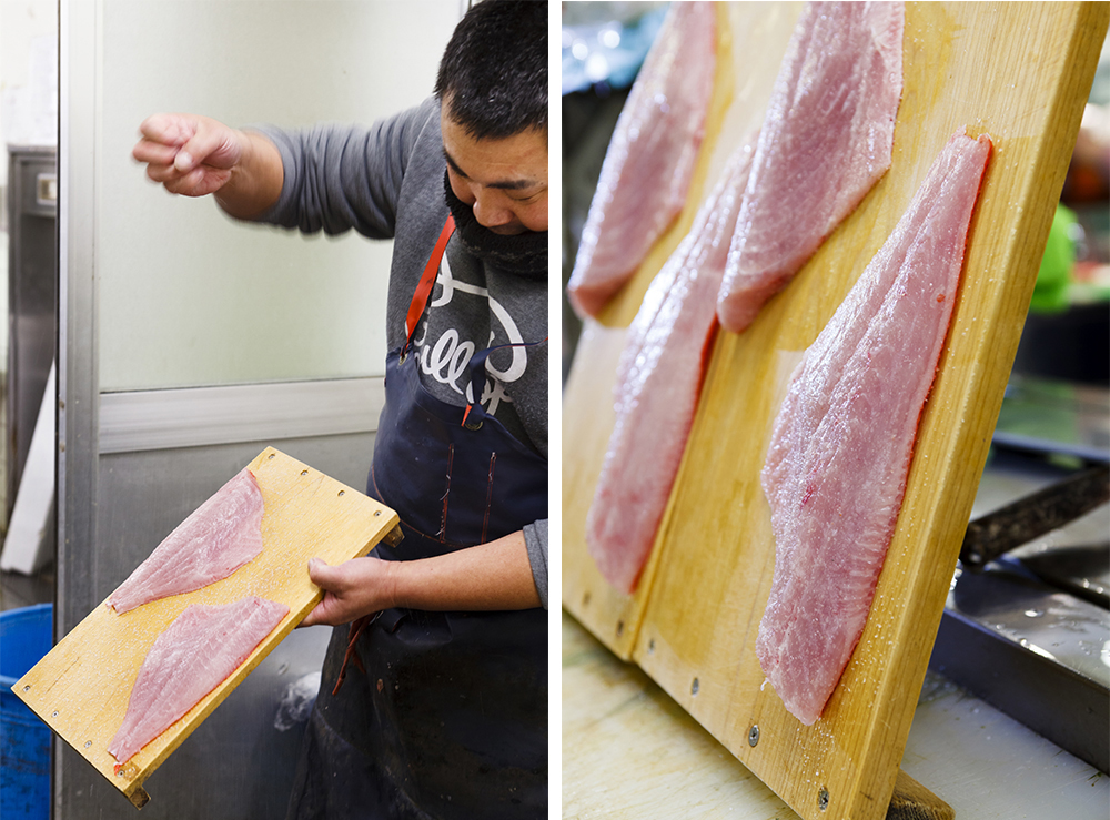 （左写真）札幌のすし店に送るキンメダイを脱水締めにする。板にのせ高い位置から均等に塩を振る。 （右写真）板を立てかける角度で脱水のスピードを調節。輸送に2日かかるのでガッチリと締める。