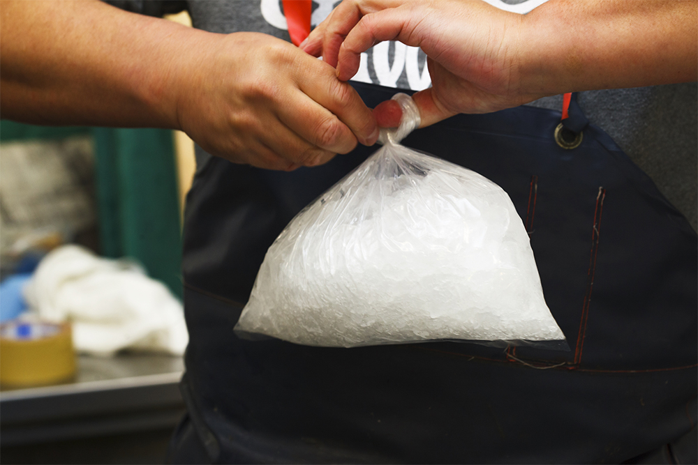 クラッシュアイスを空気を抜くようにビニール袋に詰め、平らにして箱の底に並べる。