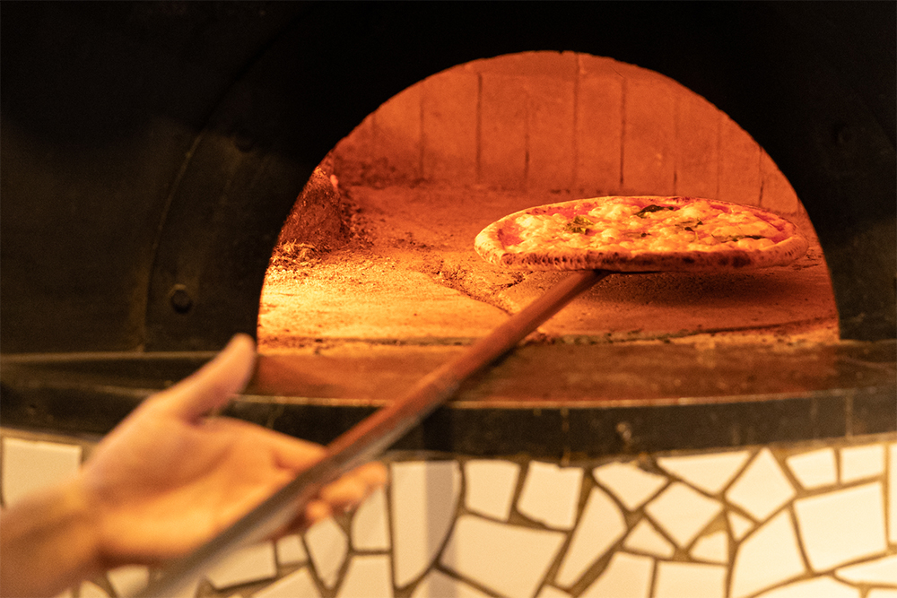 チーズ、トマトソース、オリーブオイルが混じり合って乳化したタイミングで取り出す。チーズやトマトソースを使わないシラスのピッツァなど、食材によって見極めが必要だ。