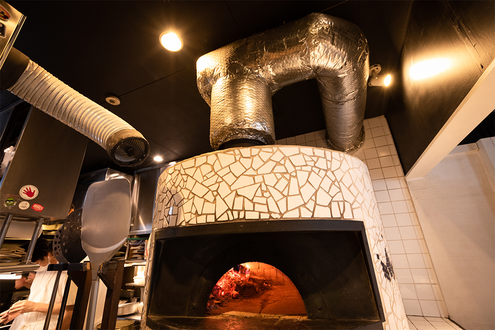 排気は万全。都市部の薪火調理には、熱と煙をスムーズに外へ出す設備が不可欠。