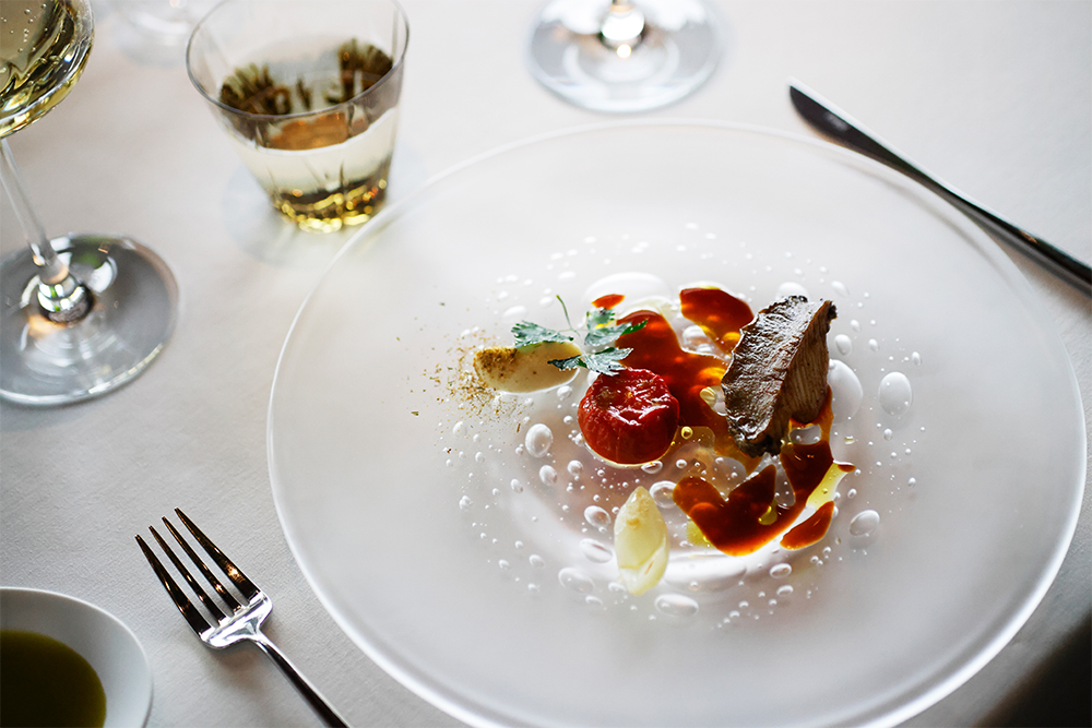 鮑と同系のグルタミン酸の旨味をもつトマトを、ソースとガルニチュールに登用。低温のオーブンでじっくり水分を枯らし、濃縮した甘味と酸味を引き出した焼きトマトが、主役の鮑に負けない存在感を放つ。