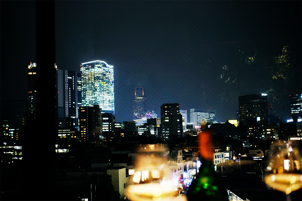 明治神宮前駅と表参道駅を結ぶ、けやき並木通り沿いの一等地に立地。壁面いっぱいのガラス窓に広がる夜景が美しい。