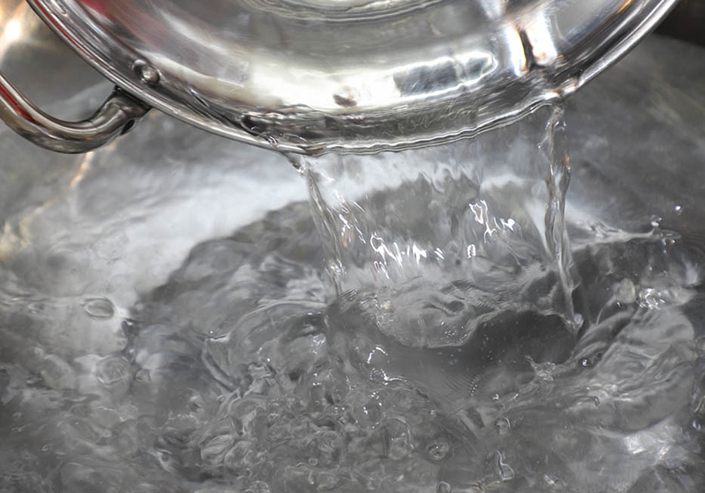 [２]型を温める 大鍋に湯を沸かす。春雨を流す型を湯にくぐらせ、しっかり温めておく。