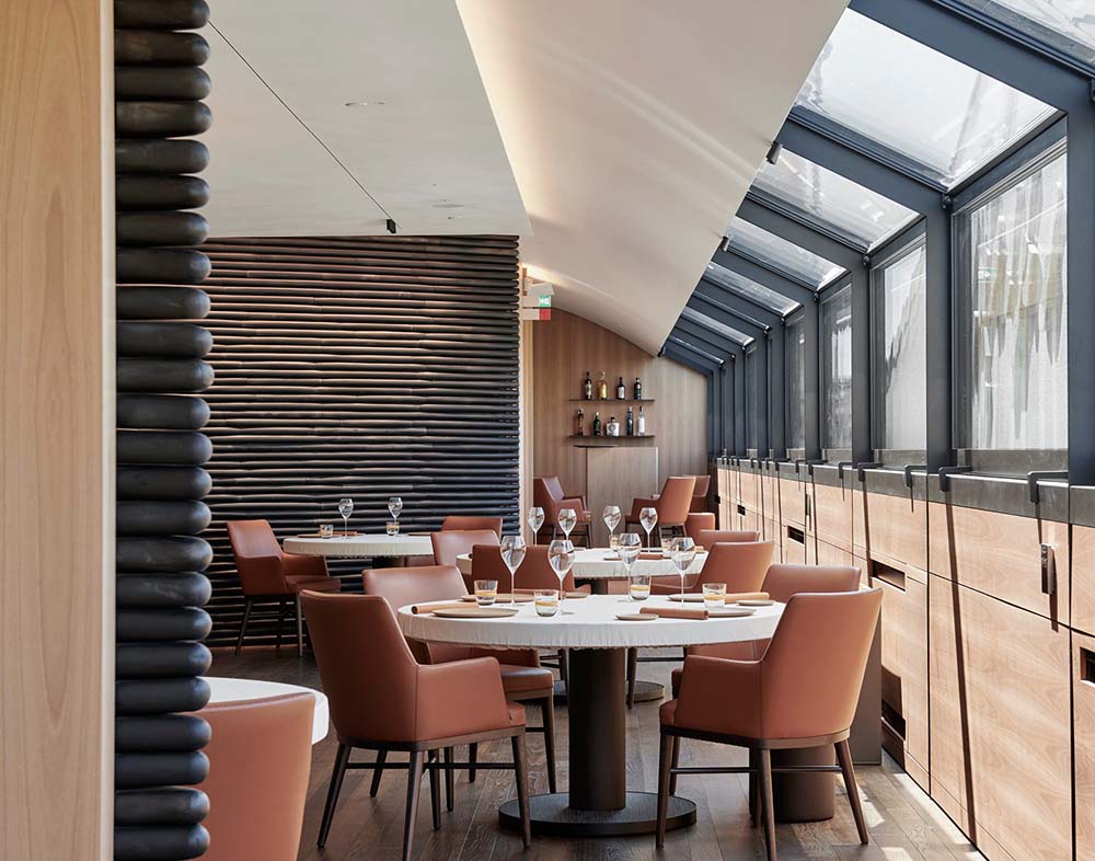 （写真）最上階にあるレストランは、ゆったりとしてスタイリッシュ。ガラス張りの窓からは向かいにあるジャルディーノ公園の緑やプラネタリウムの屋根、遠くには新興地区のモダンな高層ビル群も見える。キッチンは全面ガラス張りで、調理が進む様子がつぶさに見える。