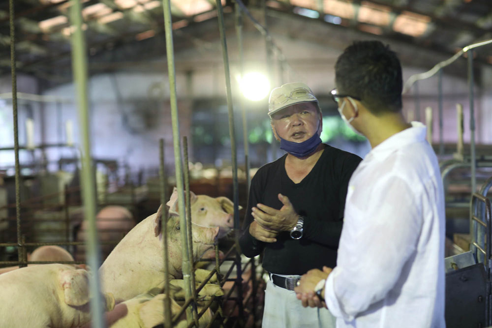 顧問の前花安範さん（左）は、養豚歴５年。石垣牛を育てていた期間もあり、微生物を用いた環境浄化の知見と経験豊かなアイデアマンだ。説明を聞きながら、「豚舎がほとんど臭わないことに驚きました。健全に育てていることの証左ですよね」と感心しきりの久岡シェフ。