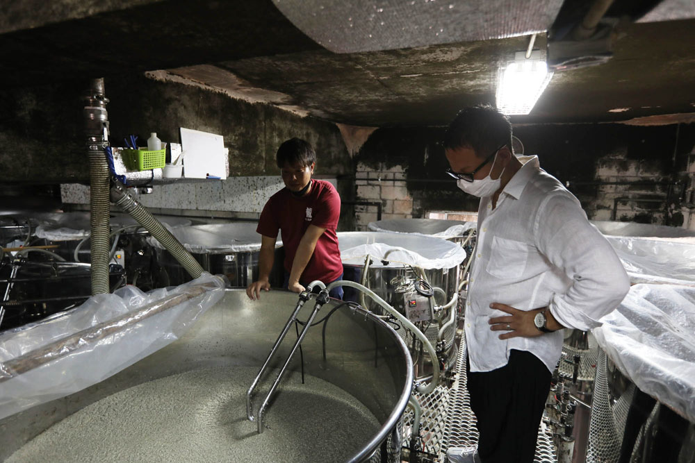 仕込み室には発酵中のもろみのタンクがすらりと並び、壮観。泡盛には黒麹が使われるため、もろみの色もグレーがかっている。