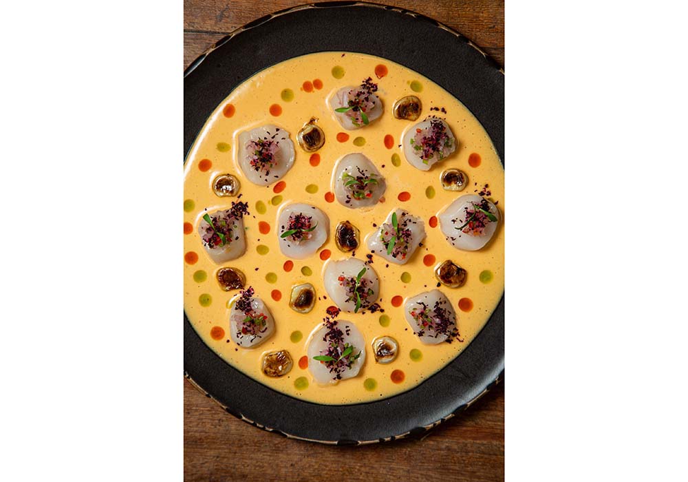 （写真２枚目）「Tiradito de Conchas Thai」（45ソレス）。ホタテのティラディートにタイ風レチェ・デ・ティグレと日本のシソをプラスしたアジアン・ペルビアンらしい一品。