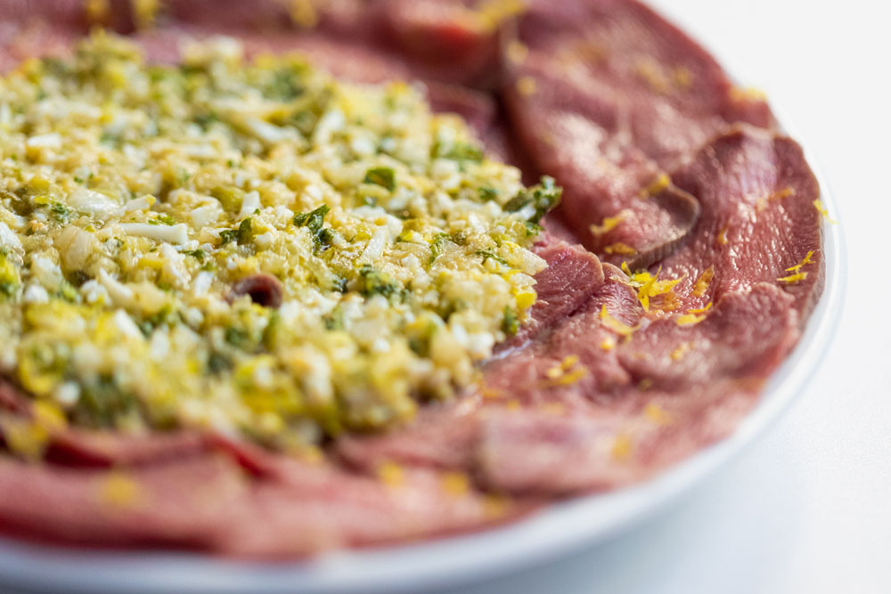 料理：「牛タンのカルパッチョ　グリビッシュソース掛け」 低温調理した牛タンのスライスにグリビッシュソースの酸味とレモンの皮の香りをのせて。脂の少ない牛タンの先を使い、あっさりとした肉の旨味を楽しませる。