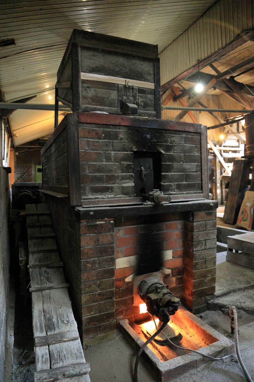 小麦を炒るのはレンガ造りの焙煎機。小麦を熱した砂の中をくぐらせて加熱する。小麦の流量を調整しながらムラのないように炒り上げる。