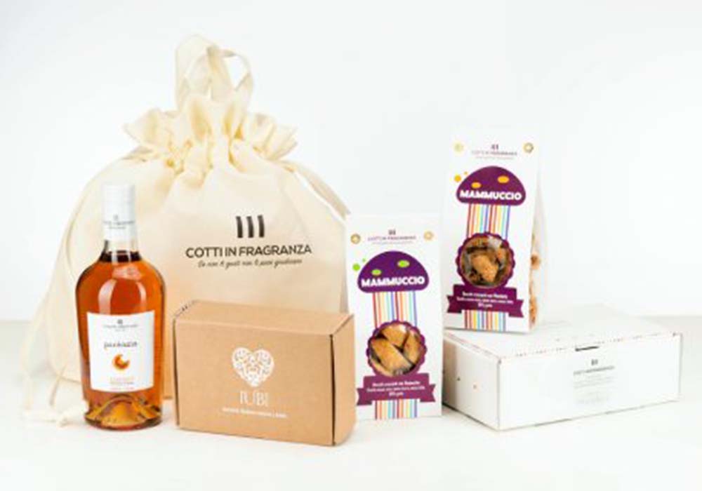 （写真）主力商品はシチリア名物であるピスタチオや柑橘を使った焼き菓子。マンダリンビスケット「ブオン・クオーレ」は、シャクリという品種の柑橘を収穫することろから始まり、できるだけ無農薬で栽培された材料を使う。2022年のクリスマスには３種類のパネットーネもリリースし、ミラノの有名菓子店と変わらない高価格で販売された。写真はギフトセット「Cesta Duci e Pacenzia」50ユーロ。