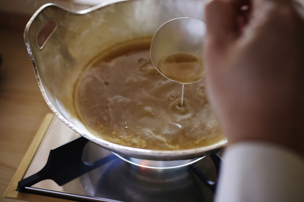 「伊勢海老の唐揚げ」の仕上げに張る黄金色のとろみあんは、伊勢海老の頭や殻を香ばしく焼いてつぶし、３時間かけて煮込んだ後に海老の味噌を溶き入れ、醤油で薄く味をつけて仕上げたもの。ビスクを思合わせる濃厚な香りがたちこめる。