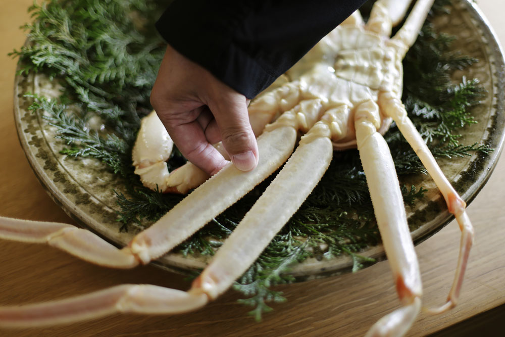 カニの脚に触れるだけで「身の詰まり具合、味の濃さがわかる」と刀根さん。目利きだけでなく、鮮度の保ち方、保管方法、茹で方にも熟練の技が必要だ。