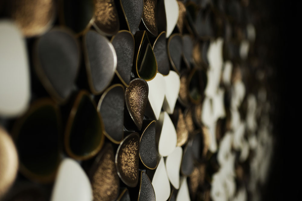 フロントの背景には、荒ぶる日本海を織部焼や越前焼きの鋼石で表現したコラージュが。モダンな中にも陰影礼賛の美学が息づく意匠が目を楽しませてくれる。