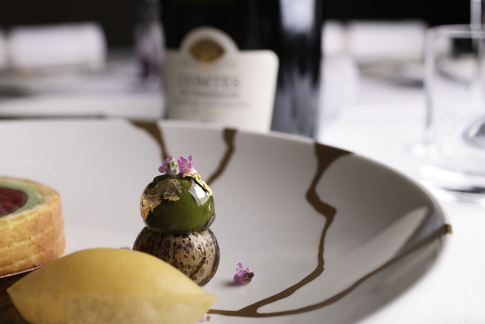 ２段仕立ての球形のガルニチュール。下は小タマネギをくり抜き、メインの調理で残る牛舌の端肉とともにローストしてサワークリームで和え、詰めたもの。上部の緑の球体は、タマネギとシソのピューレ。柚子皮とシブレットを添える。