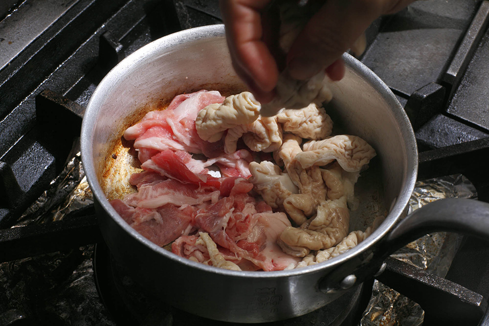 モツ、コマ肉を炒める