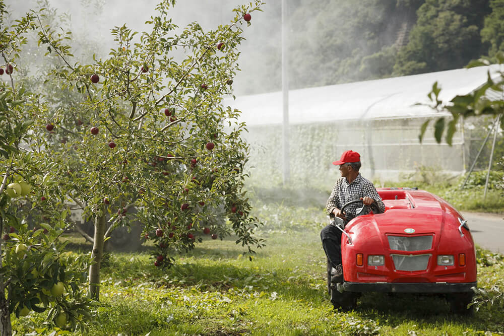 畑に栄養剤を撒く留目さん
