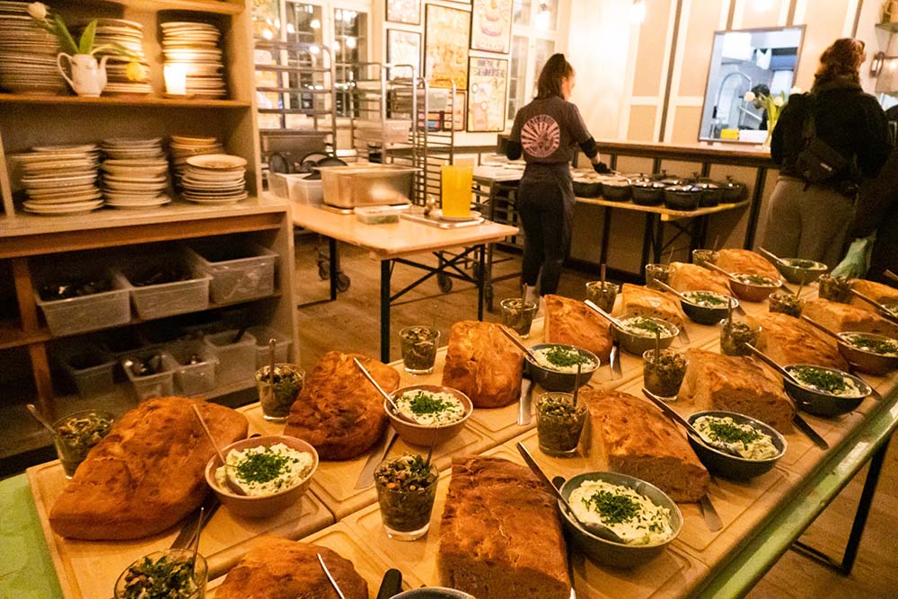 （写真）アブサロンのフェッレスピースニンのキッチン。各テーブルには８人ほどが座り、その中で話し合って決めた代表２人がここまで食事を取りに来る。