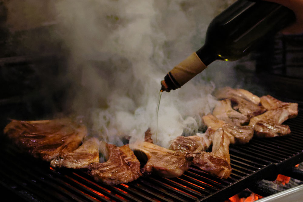 仕上げにオリーブオイルをかけて煙を立たせ、表面を焦がす。