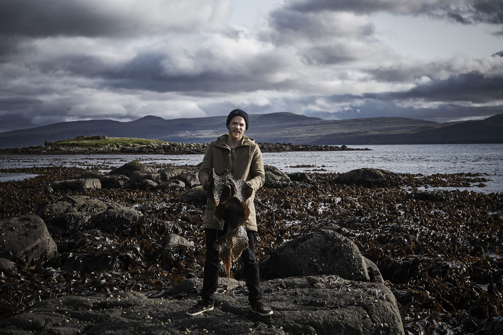 海藻を手に持つポール・アンドリアス。島のどこも海から５km離れることはない。レストランから10分の距離に素材が眠る。彼にとってはあらゆる素材が新しい一品のための有力候補。 ©Claes Bech-Poulsen