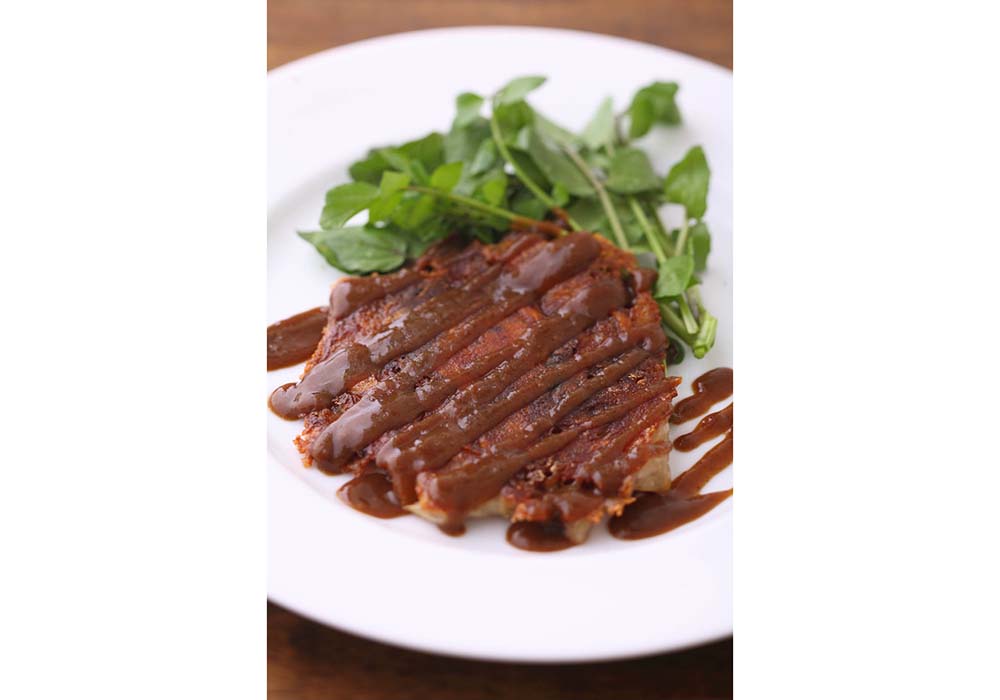 フロマージュ・ド・テットを春巻きの皮に包んで焼いた「豚のコラーゲンパリパリ焼き」にウスターソースをかけてお好み焼き風に。