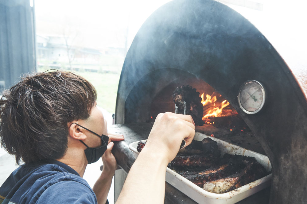 クルックフィールズに昨年オープンしたレストラン「perus（ペルース）」の山名新貴（よしき）シェフは、ピザ窯で大原産のタコを調理中。参加者が摘んだ山野草と一緒にセビーチェにします。