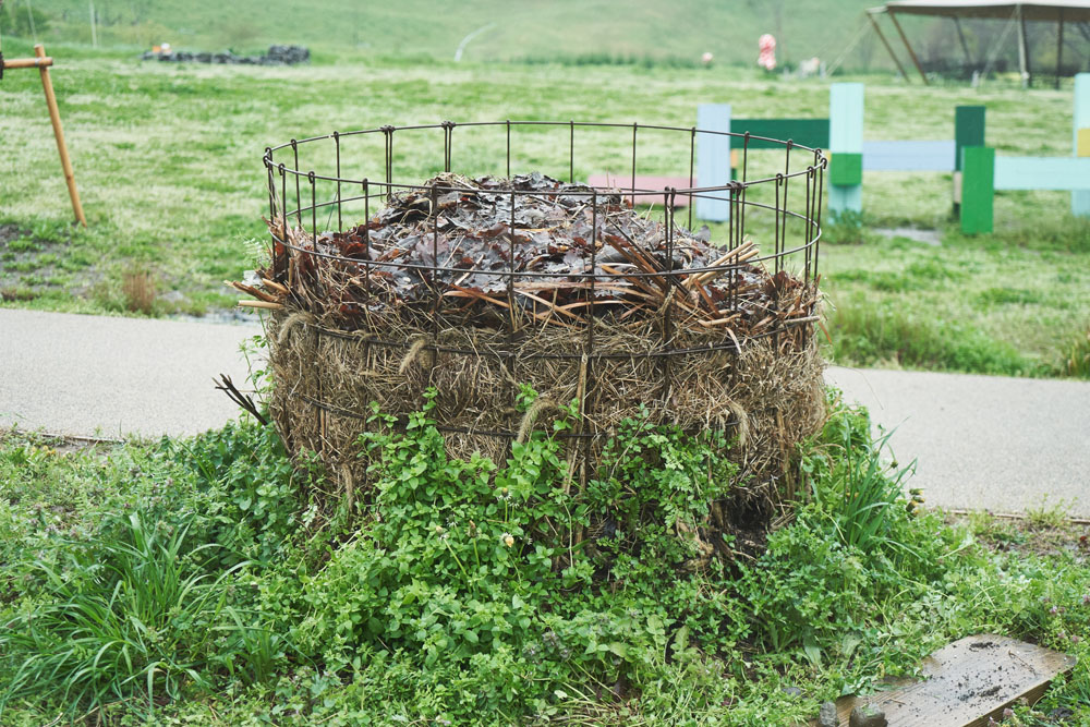 こちらは農場で刈り取った雑草を堆肥化中。水はけがよい柵の中で虫や微生物によって発酵・分解され、下のほうから植物由来の堆肥が出来上がります。