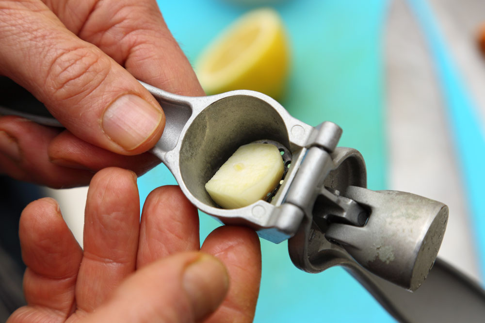 ニンニクは潰して使う ニンニクは刻んでもよいが、細かく潰して使うと食感が馴染みやすい。手を汚さず簡単にニンニクを潰せるスクイーザーが必需品。